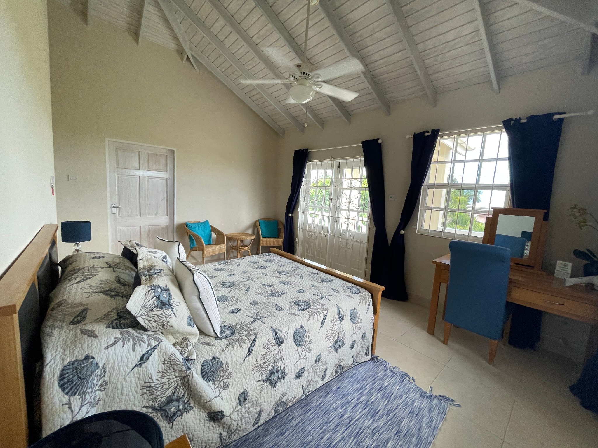 Holland Park Villa master bedroom with king bed, ceiling fan and balcony doors